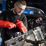 Foto: Kfz Mechaniker schraubt an einem Elektromotor