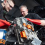 Foto: zwei Kfz Mechaniker reparieren einen Elektromotor